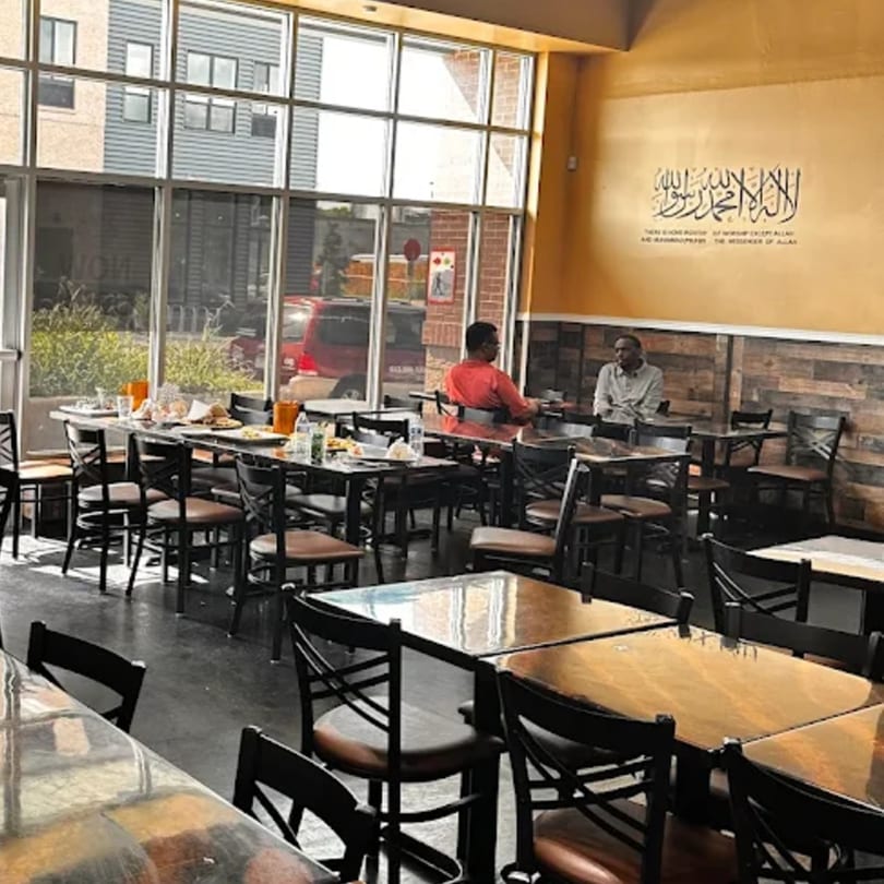 Interior of Quruxley Restaurant with two men seated at tables and food on other tables.
