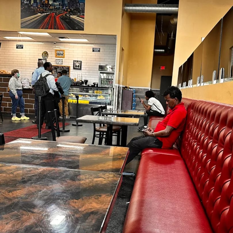 Customers wait in line at the counter and sit at tables in Quruxley Restaurant.